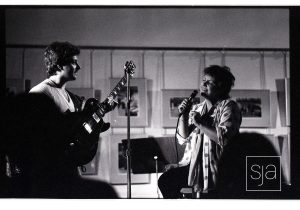Man playing guitar and woman singing.