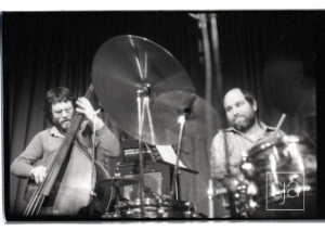Double bassist and drummer playing.