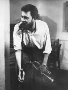 Man with trumpet singing into a microphone