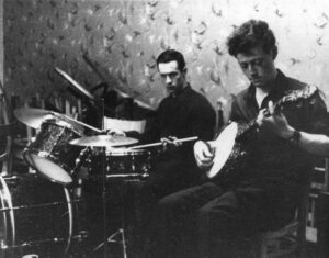 Left to right: Man playing drum kit, man playing banjo