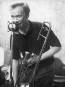 Man with trombone singing into a microphone