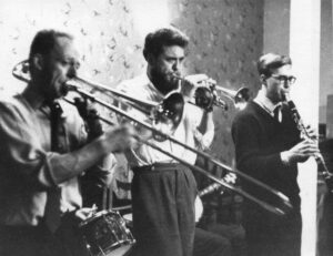 Jazz band Left to right: Man playing trombone, man playing trumpet, man playing clarinet.